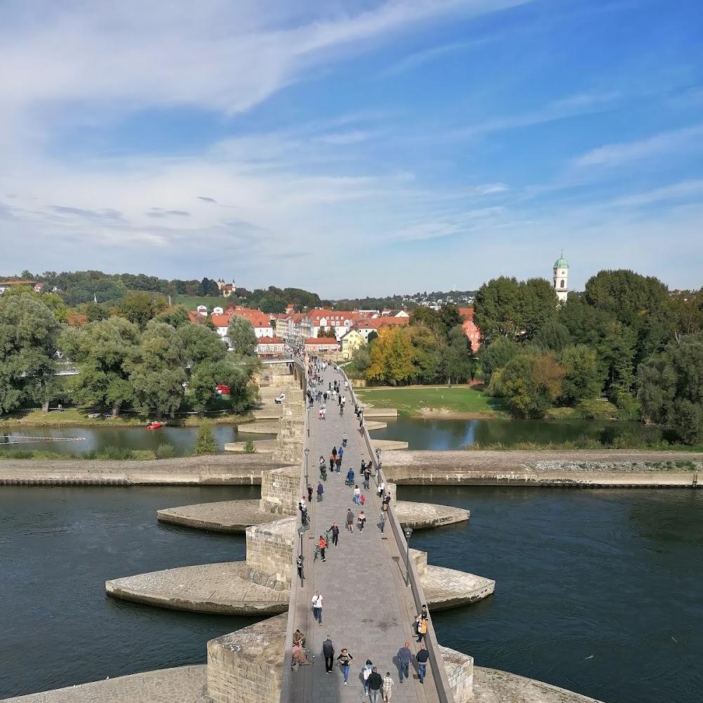 Stone bridge with people walking, Regensburg, Germany.